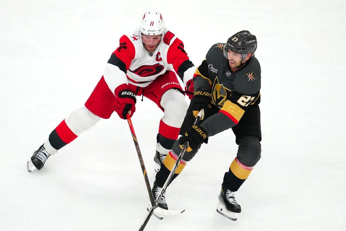 Oct 20, 2025; Las Vegas, Nevada, USA; Vegas Golden Knights defenseman Shea Theodore (27) skates against Carolina Hurricanes center Jordan Staal (11) during the second period at T-Mobile Arena. Mandatory Credit: Stephen R. Sylvanie-Imagn Images