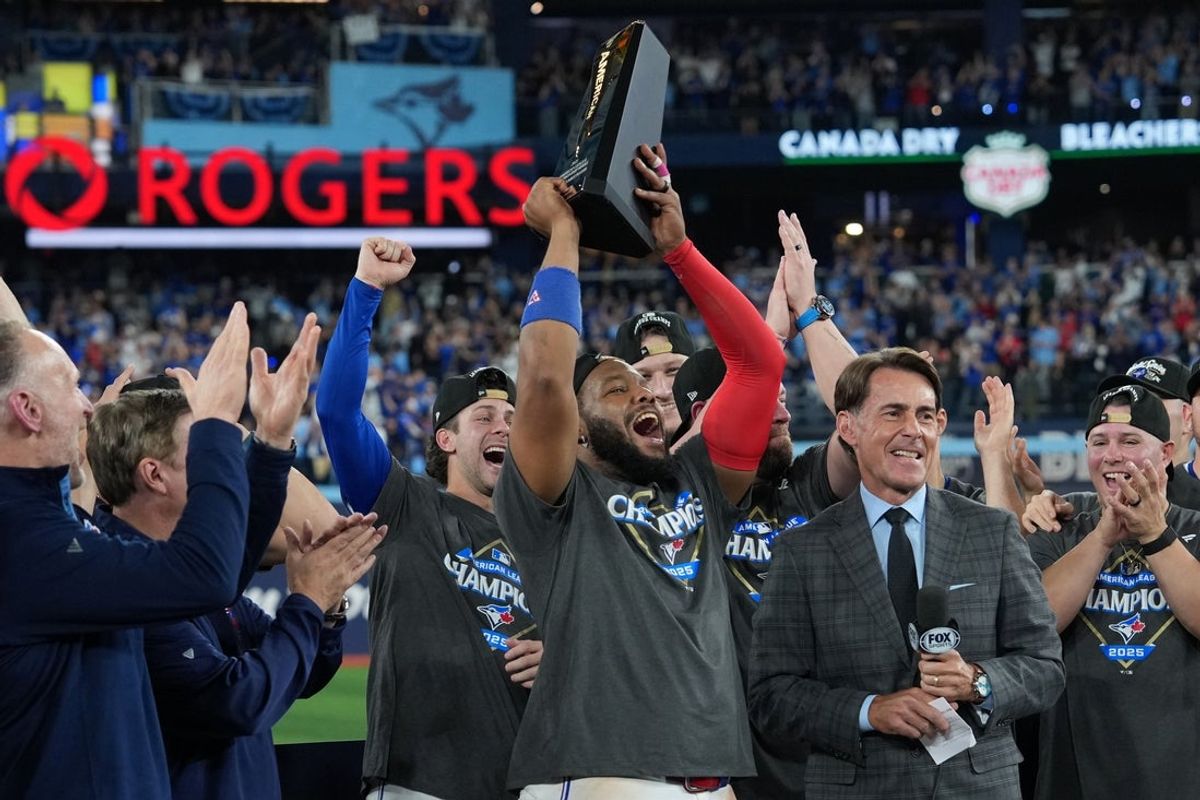 Oct 20, 2025; Toronto, Ontario, CAN; Toronto Blue Jays first baseman Vladimir Guerrero Jr. (27) celebrates with the trophy after defeating the Seattle Mariners in game seven of the ALCS round for the 2025 MLB playoffs at Rogers Centre. Mandatory Credit: Nick Turchiaro-Imagn Images