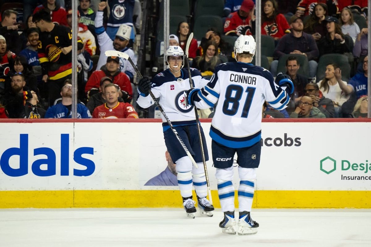 Oct 20, 2025; Calgary, Alberta, CAN; Winnipeg Jets center Mark Scheifele (55) celebrates with left wing Kyle Connor (81) after scoring a goal against the Calgary Flames during the third period at Scotiabank Saddledome. Mandatory Credit: Brett Holmes-Imagn Images