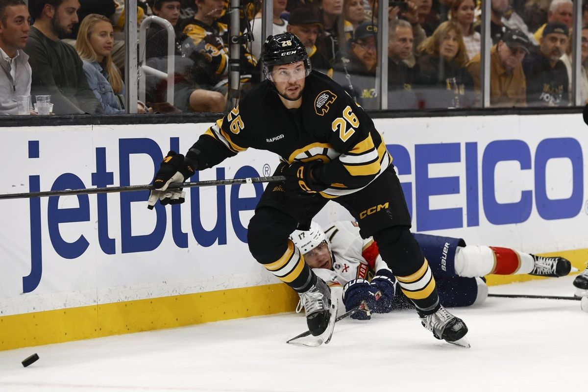 Oct 21, 2025; Boston, Massachusetts, USA; Boston Bruins defenseman Andrew Peeke (26) looks to move the puck after knocking down Florida Panthers center Evan Rodrigues (17) during the first period at TD Garden. Mandatory Credit: Winslow Townson-Imagn Images