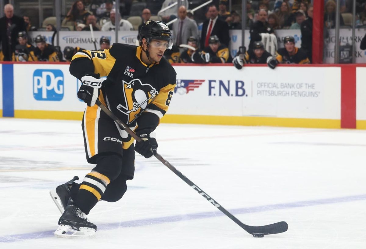 Oct 21, 2025; Pittsburgh, Pennsylvania, USA;  Pittsburgh Penguins defenseman Caleb Jones (82) handles the puck against the Vancouver Canucks during the third period at PPG Paints Arena. Mandatory Credit: Charles LeClaire-Imagn Images