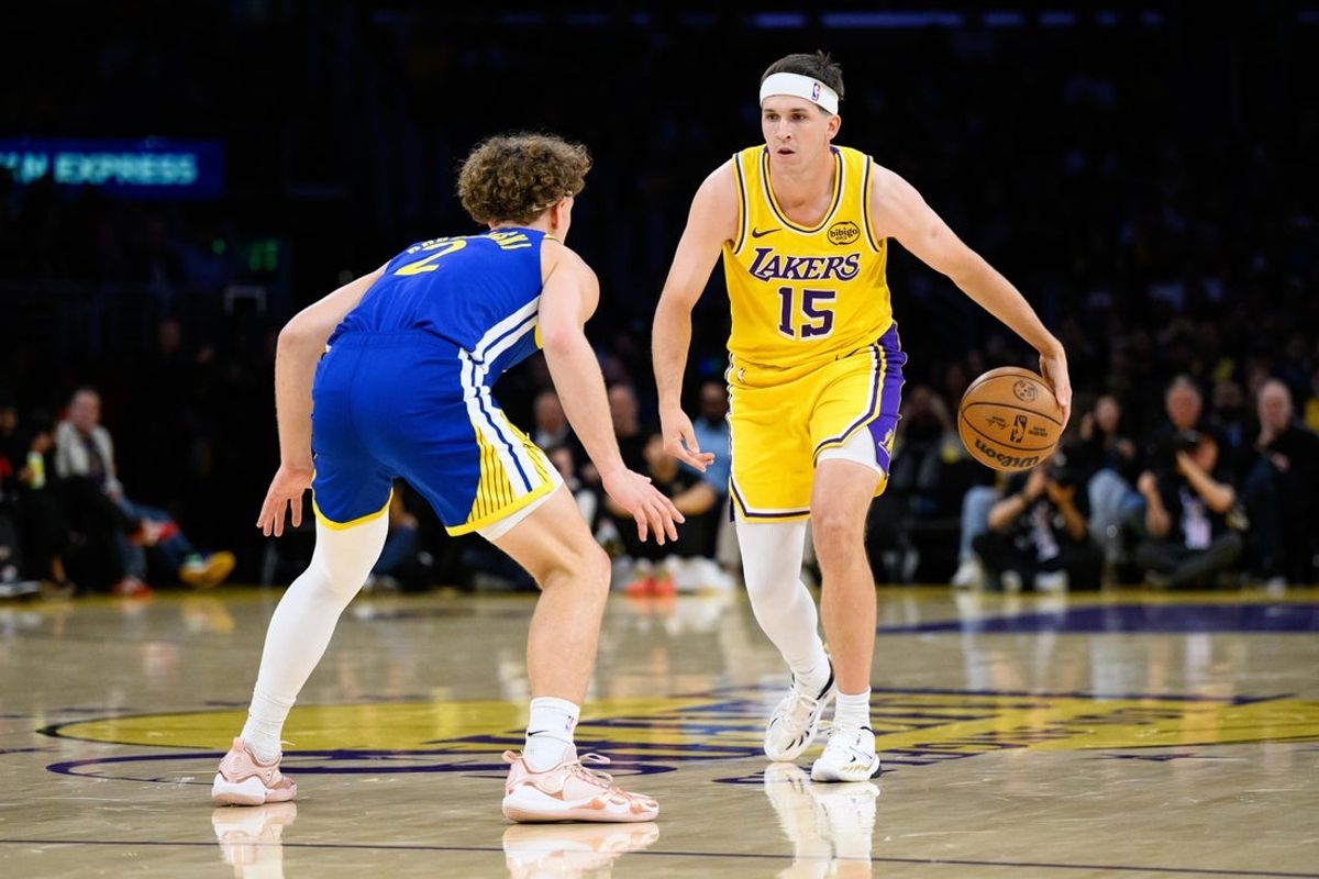 Oct 21, 2025; Los Angeles, California, USA; Los Angeles Lakers guard Austin Reaves (15) dribbles against Golden State Warriors guard Brandin Podziemski (2) during the first half at Crypto.com Arena. Mandatory Credit: William Liang-Imagn Images