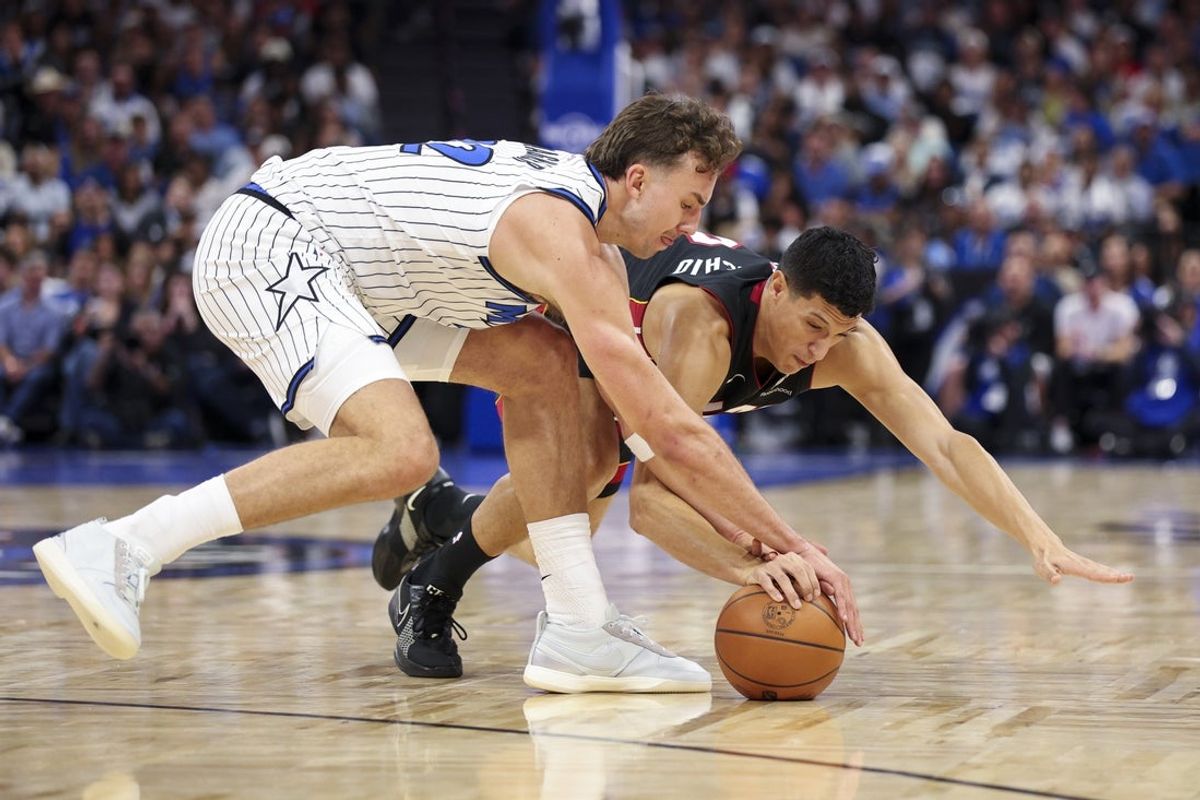Oct 22, 2025; Orlando, Florida, USA; Orlando Magic forward Franz Wagner (22) and Miami Heat forward Simone Fontecchio (0) fight for a loose ball in the first quarter at Kia Center. Mandatory Credit: Nathan Ray Seebeck-Imagn Images