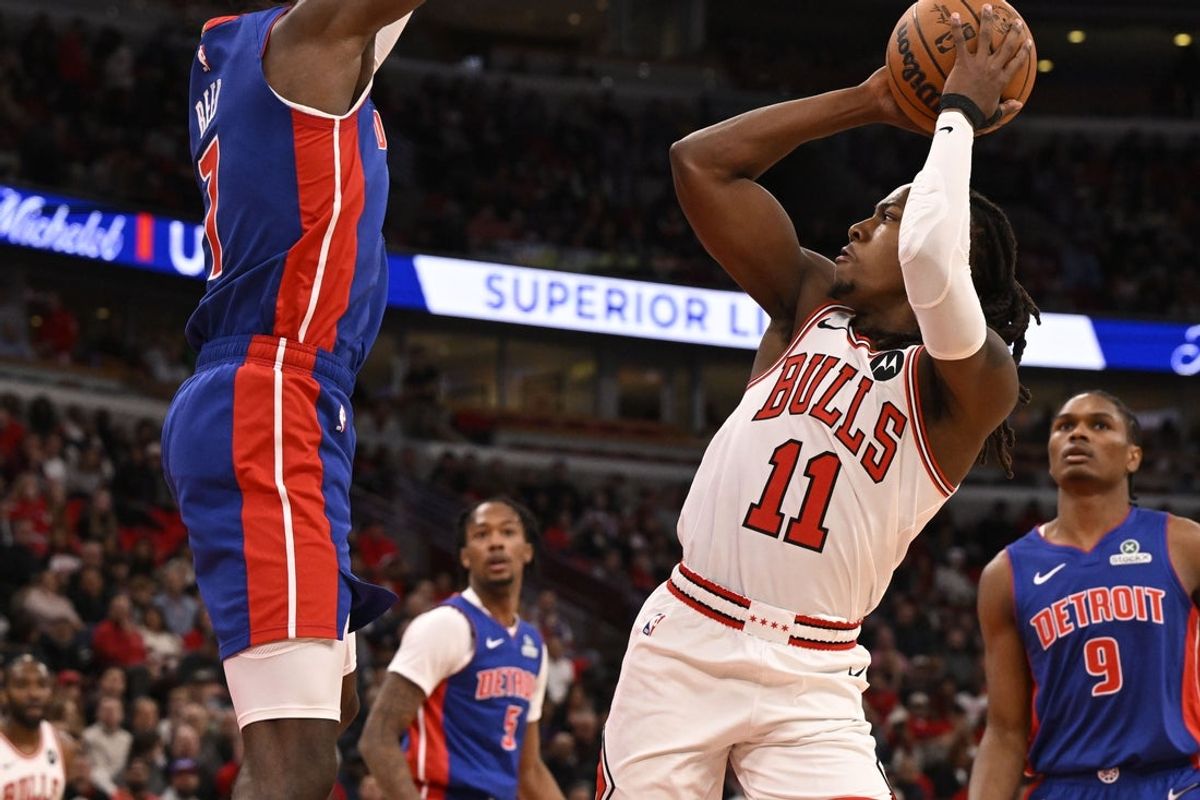 Oct 22, 2025; Chicago, Illinois, USA;  Chicago Bulls guard Ayo Dosunmu (11) shoots against Detroit Pistons forward Paul Reed (7) during the first half at United Center. Mandatory Credit: Matt Marton-Imagn Images