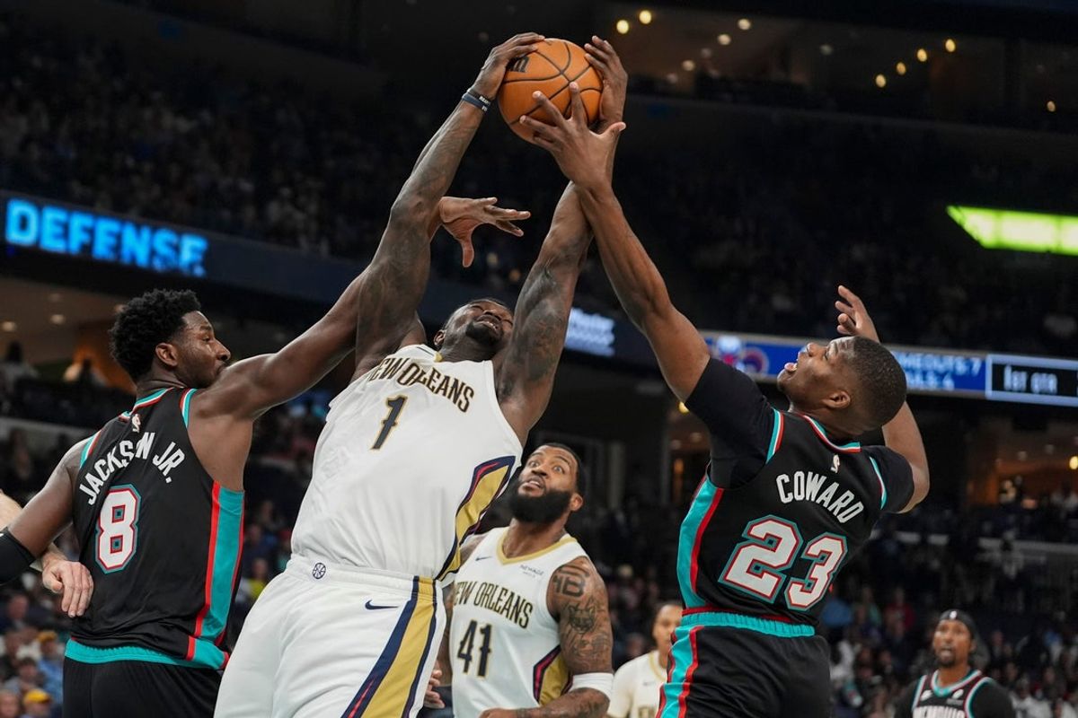 Pelicans' Zion Williamson (1) goes for a layup as Grizzlies' Jaren Jackson Jr. (8) and Cedric Coward (23) guard him during the home opener against the New Orleans Pelicans at FedExForum on October 22, 2025.