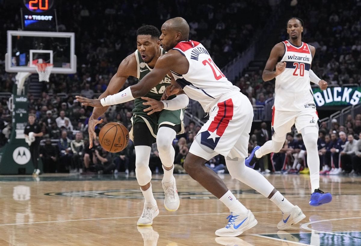 Oct 22, 2025; Milwaukee, Wisconsin, USA; Milwaukee Bucks forward Giannis Antetokounmpo (34) collides with Washington Wizards forward Khris Middleton (22) in the first half while driving to the basket in the first half at Fiserv Forum. Mandatory Credit: Michael McLoone-Imagn Images