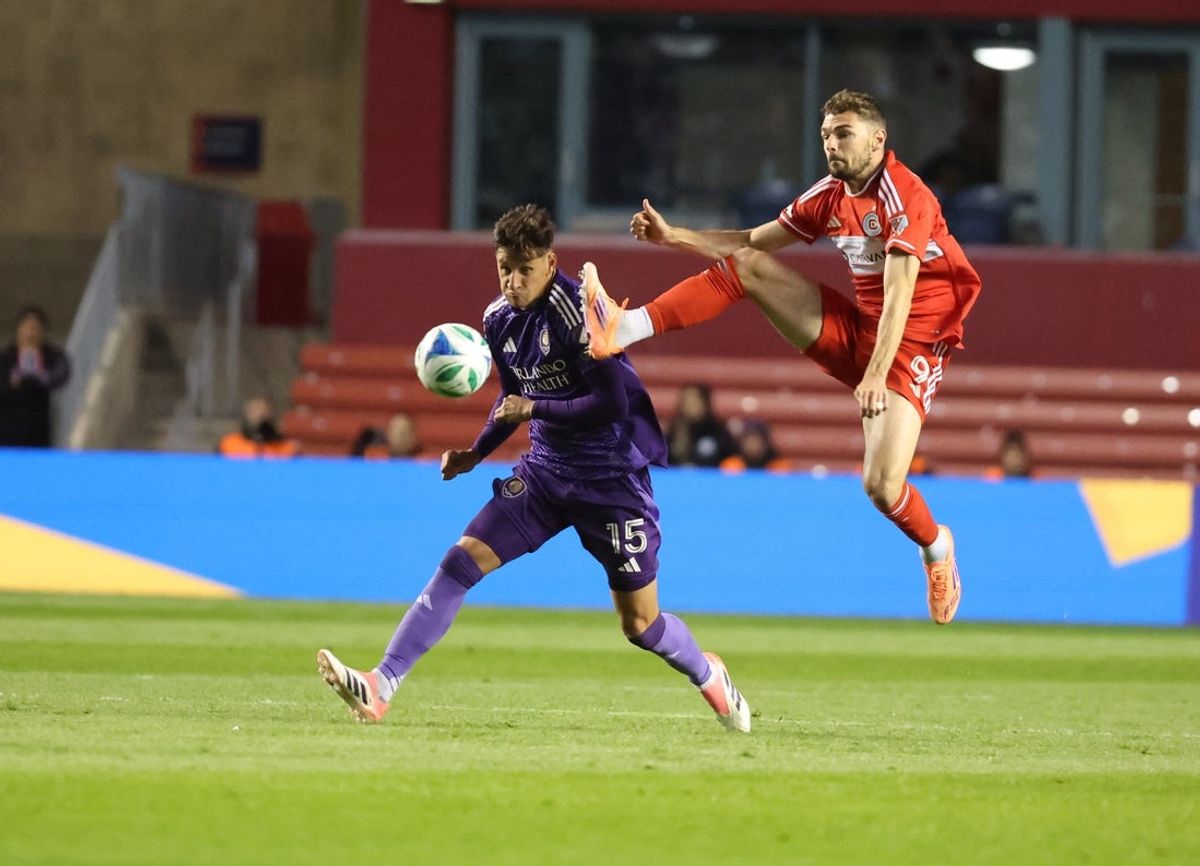 Oct 22, 2025; Bridgeview, Illinois, USA; Orlando City defender Rodrigo Schlegel (15) and Chicago Fire FC forward Hugo Cuypers (9) battle for control of the ball during the first half at SeatGeek Stadium. Mandatory Credit: Talia Sprague-Imagn Images