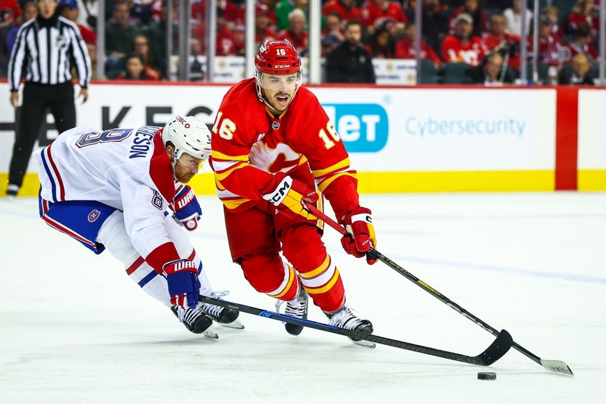 Oct 22, 2025; Calgary, Alberta, CAN; Calgary Flames center Morgan Frost (16) and Montreal Canadiens defenseman Mike Matheson (8) battles for the puck during the second period at Scotiabank Saddledome. Mandatory Credit: Sergei Belski-Imagn Images