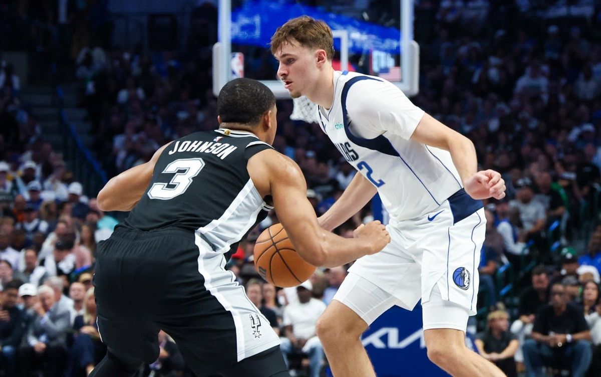 Oct 22, 2025; Dallas, Texas, USA;  Dallas Mavericks forward Cooper Flagg (32) dribbles as San Antonio Spurs forward Keldon Johnson (3) defends during the first half  at American Airlines Center. Mandatory Credit: Kevin Jairaj-Imagn Images