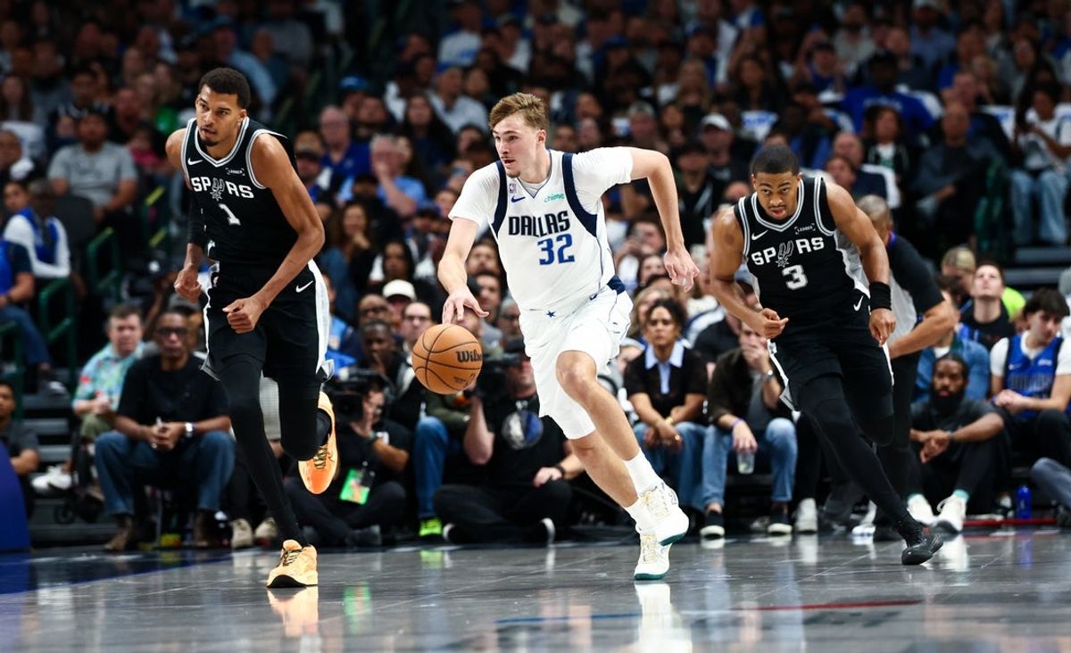 Oct 22, 2025; Dallas, Texas, USA;  Dallas Mavericks forward Cooper Flagg (32) dribbles the ball as San Antonio Spurs forward Victor Wembanyama (1) and San Antonio Spurs forward Keldon Johnson (3) chase during the first half  at American Airlines Center. Mandatory Credit: Kevin Jairaj-Imagn Images