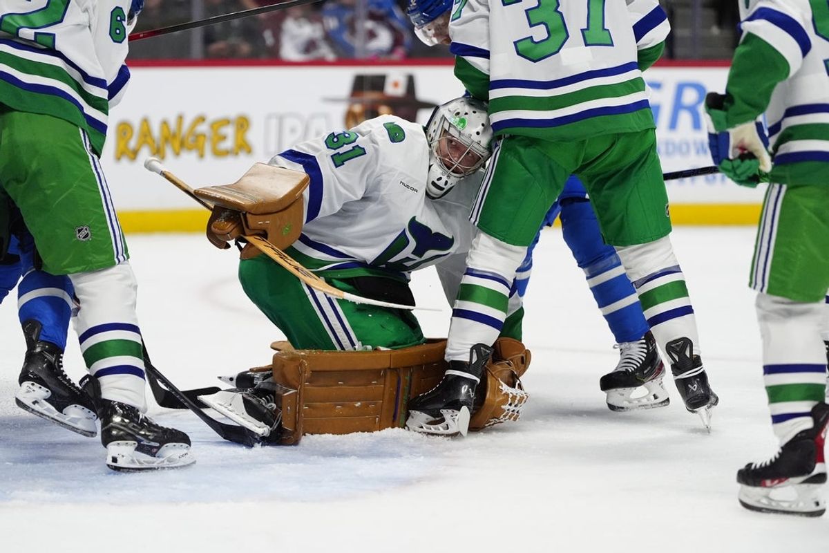 Oct 23, 2025; Denver, Colorado, USA; Carolina Hurricanes goaltender Frederik Andersen (31) covers the puck in the second period against the Colorado Avalanche at Ball Arena. Mandatory Credit: Ron Chenoy-Imagn Images