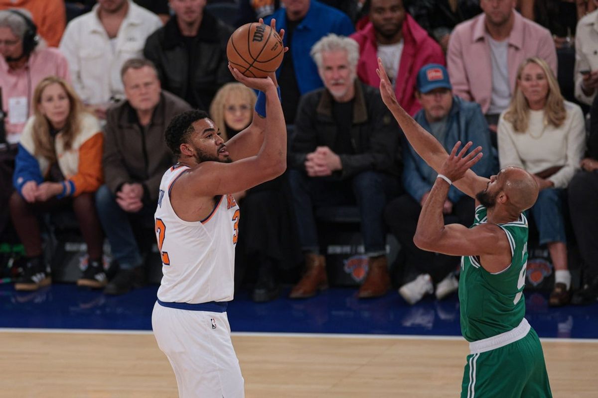 Oct 24, 2025; New York, New York, USA;  New York Knicks center Karl-Anthony Towns (32) makes a three point basket as Boston Celtics guard Derrick White (9) defends during the first quarter at Madison Square Garden. Mandatory Credit: Vincent Carchietta-Imagn Images