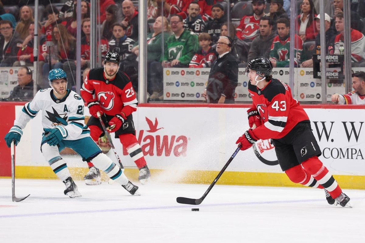 Oct 24, 2025; Newark, New Jersey, USA; New Jersey Devils defenseman Luke Hughes (43) skates with the puck as San Jose Sharks center Alexander Wennberg (21) defends during the first period at Prudential Center. Mandatory Credit: Ed Mulholland-Imagn Images