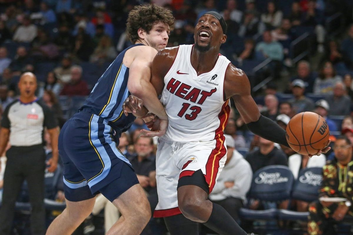 Oct 24, 2025; Memphis, Tennessee, USA; Miami Heat center Bam Adebayo (13) drives to the basket as Memphis Grizzlies center PJ Hall (16) defends during the first quarter at FedExForum. Mandatory Credit: Petre Thomas-Imagn Images