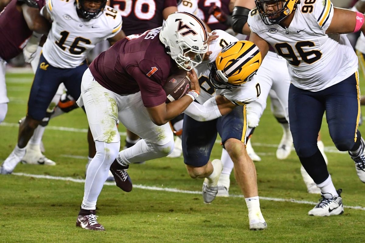 Oct 24, 2025; Blacksburg, Virginia, USA;  California Golden Bears linebacker Cade Uluave (0) tackles Virginia Tech Hokies quarterback Kyron Drones (1) as he runs the ball during the second quarter at Lane Stadium. Mandatory Credit: Brian Bishop-Imagn Images