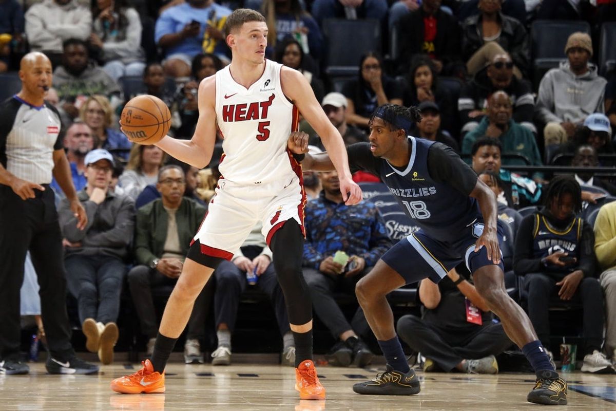 Oct 24, 2025; Memphis, Tennessee, USA; Miami Heat forward Nikola Jovic (5) handles the ball as Memphis Grizzlies forward Olivier-Maxence Prosper (18) defends during the fourth quarter at FedExForum. Mandatory Credit: Petre Thomas-Imagn Images