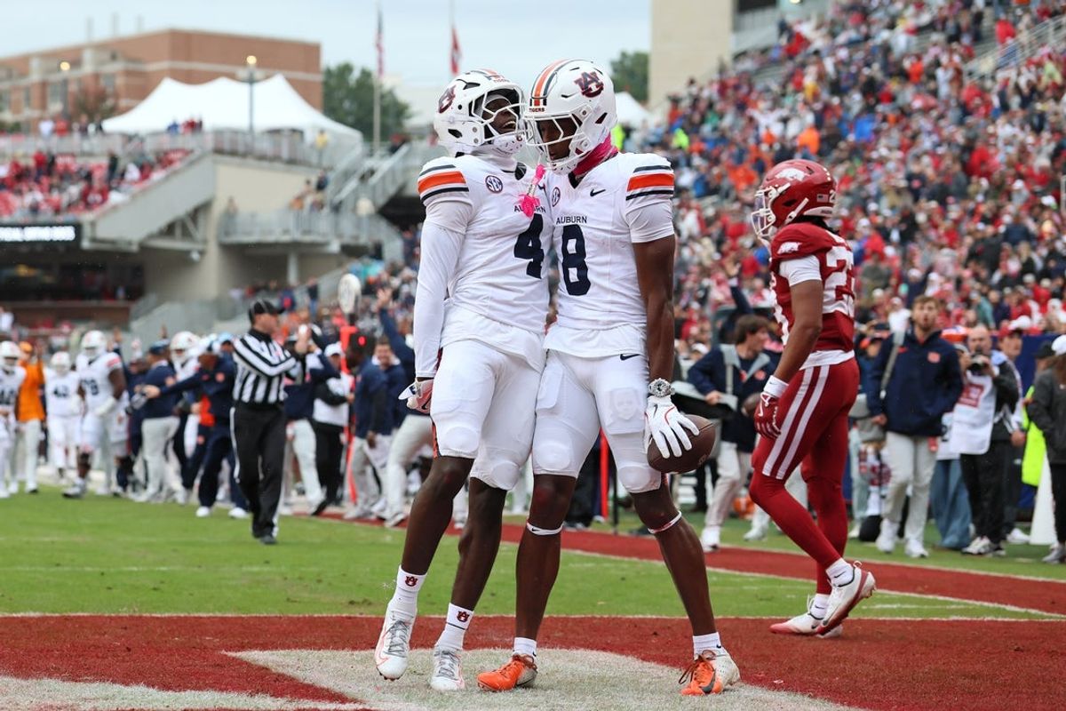 Oct 25, 2025; Fayetteville, Arkansas, USA; Auburn Tigers wide receiver Cam Coleman (8) celebrates with wide receiver Malcolm Simmons (4) after scoring a touchdown defended by Arkansas Razorbacks defensive back Julian Neal (23) during the first quarter at Donald W. Reynolds Razorback Stadium. Mandatory Credit: Nelson Chenault-Imagn Images