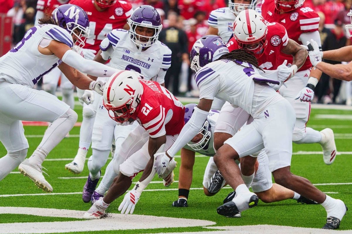 Oct 25, 2025; Lincoln, Nebraska, USA; Nebraska Cornhuskers running back Emmett Johnson (21) runs against Northwestern Wildcats cornerback Fred Davis II (2), defensive back Garner Wallace (18) and cornerback Fred Davis II (2) during the first quarter at Memorial Stadium. Mandatory Credit: Dylan Widger-Imagn Images
