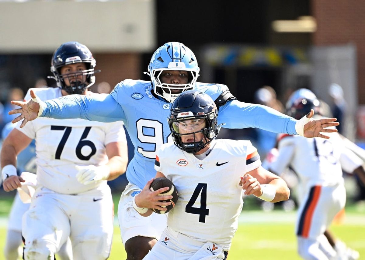 Oct 25, 2025; Chapel Hill, North Carolina, USA;  North Carolina Tar Heels defensive lineman Isaiah Johnson (94) sacks Virginia Cavaliers quarterback Chandler Morris (4) in the second quarer at Kenan Stadium. Mandatory Credit: Bob Donnan-Imagn Images