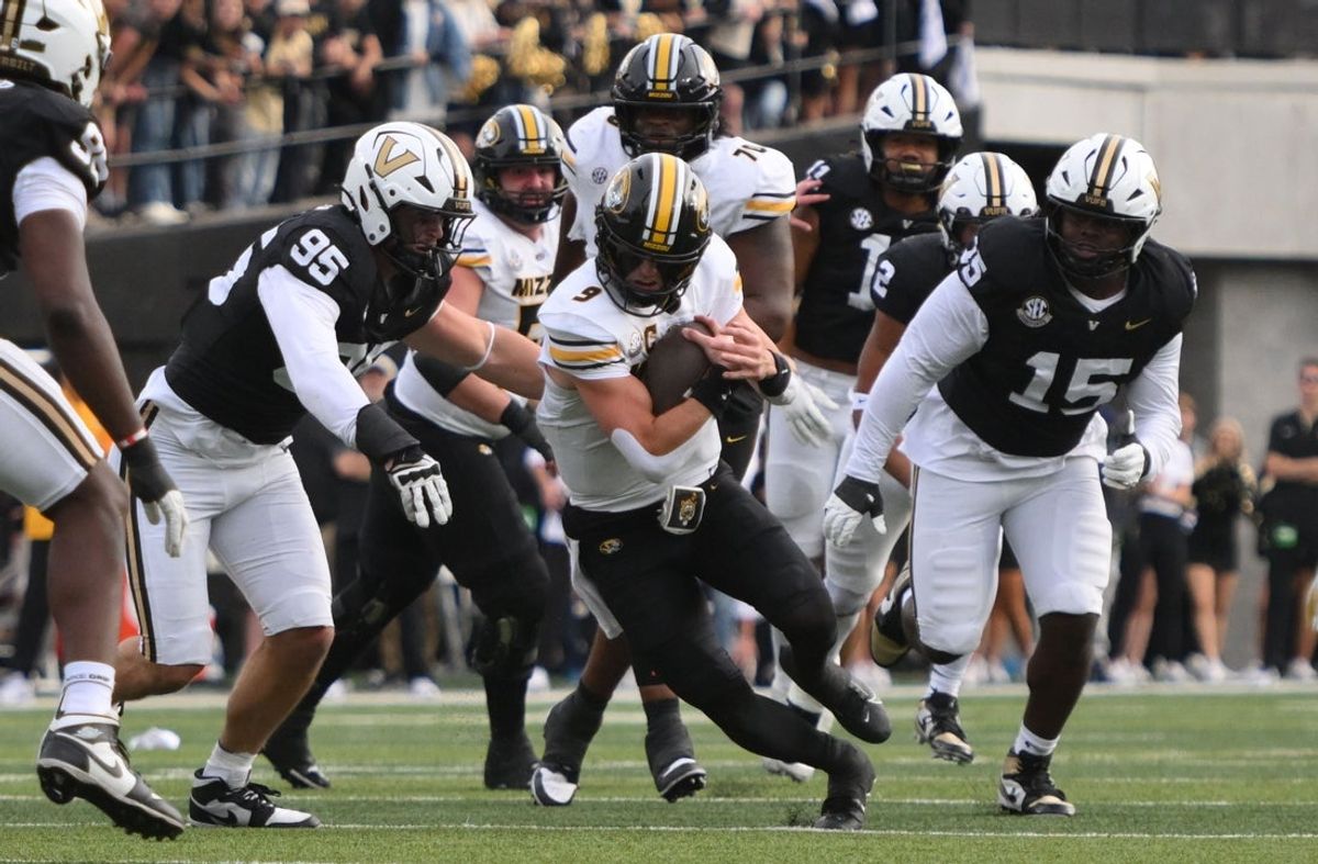 Oct 25, 2025; Nashville, Tennessee, USA; Missouri Tigers quarterback Beau Pribula (9) runs while defended by Vanderbilt Commodores defensive lineman Linus Zunk (95) during the second quarter at FirstBank Stadium. Mandatory Credit: Steve Roberts-Imagn Images