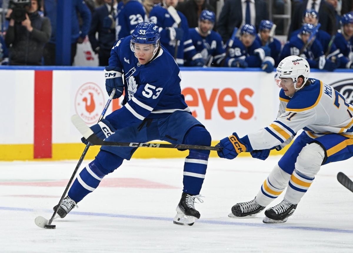 Oct 25, 2025; Toronto, Ontario, CAN; Toronto Maple Leafs right wing Easton Cowan (53) is defended by Buffalo Sabres center Ryan McLeod (71) in the first period at Scotiabank Arena. Mandatory Credit: Gerry Angus-Imagn Images