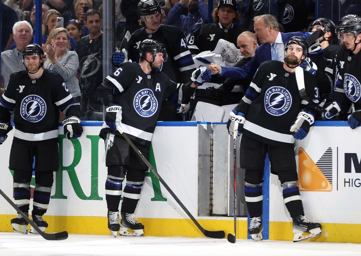 Oct 25, 2025; Tampa, Florida, USA; Tampa Bay Lightning right wing Nikita Kucherov (86) is congratulated by head coach Jon Cooper after he got an assist and his 1,000 career point against the Anaheim Ducks during the second period at Benchmark International Arena. Mandatory Credit: Kim Klement Neitzel-Imagn Images