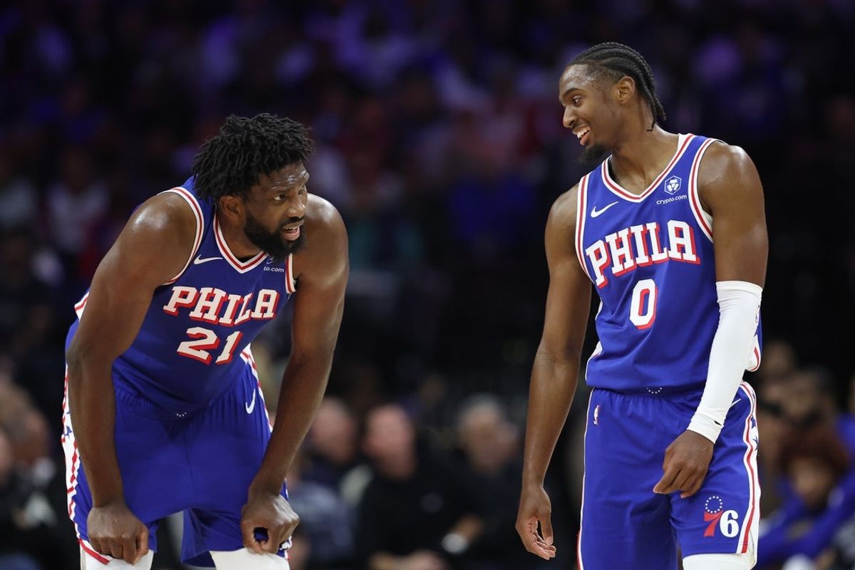 Oct 25, 2025; Philadelphia, Pennsylvania, USA; Philadelphia 76ers guard Tyrese Maxey (0) and center Joel Embiid (21) talks during a break in action in the second quarter against the Charlotte Hornets at Xfinity Mobile Arena. Mandatory Credit: Bill Streicher-Imagn Images