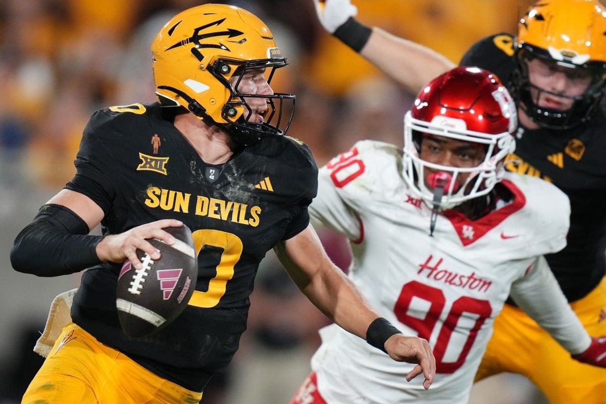 ASU Sun Devils quarterback Sam Leavitt (10) scrambles away from Houston Cougars defensive lineman Eddie Walls III (90) at Mountain America Stadium in Tempe on Oct. 25, 2025.