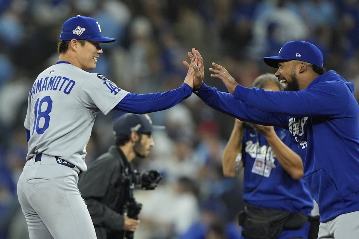 Oct 25, 2025; Toronto, Ontario, CAN; Los Angeles Dodgers pitcher Yoshinobu Yamamoto (18) celebrates with right fielder Teoscar Hernandez (37) after defeating the Toronto Blue Jays in game two of the 2025 MLB World Series at Rogers Centre. Mandatory Credit: John E. Sokolowski-Imagn Images