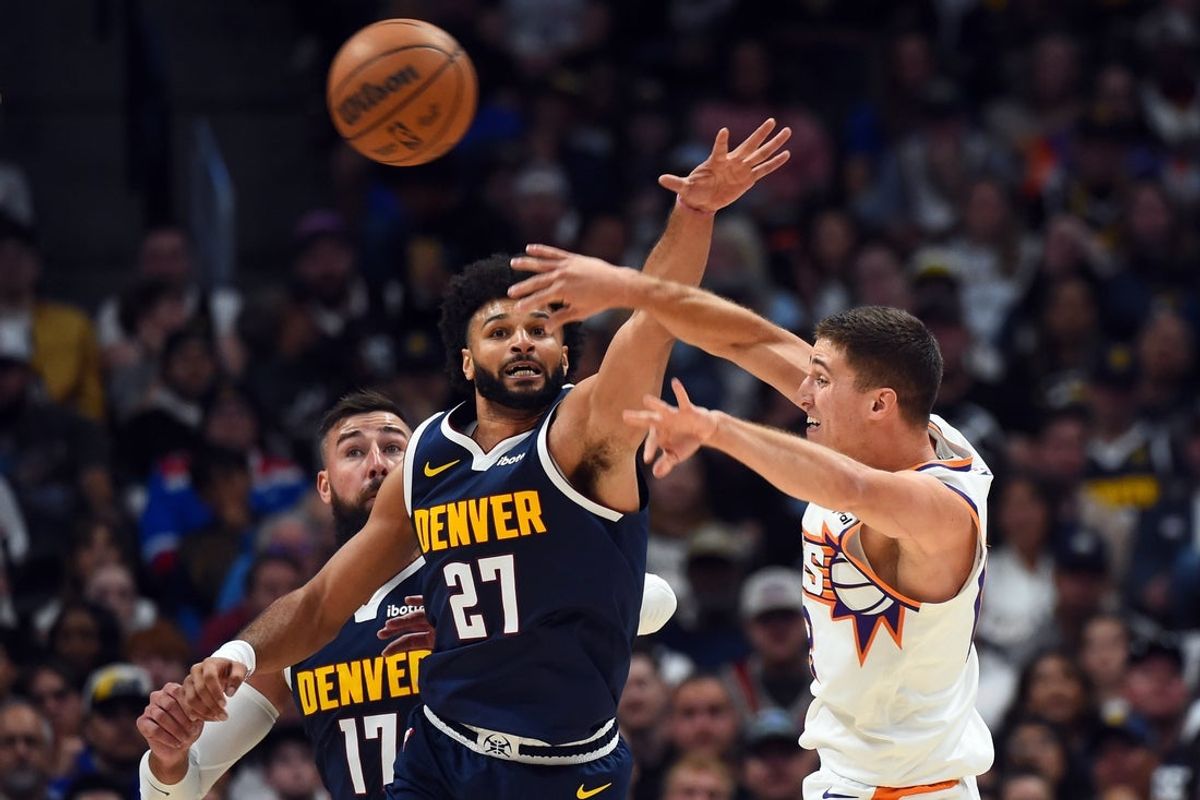 Oct 25, 2025; Denver, Colorado, USA; Phoenix Suns guard Collin Gillespie (12) passes the ball as he is defended by Denver Nuggets guard Jamal Murray (27) during the first half at Ball Arena. Mandatory Credit: Christopher Hanewinckel-Imagn Images
