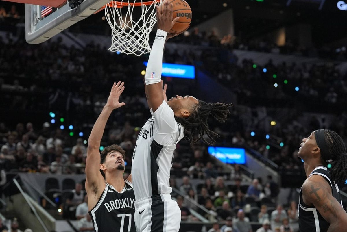 Oct 26, 2025; San Antonio, Texas, USA; San Antonio Spurs guard Stephon Castle (5) shoots over Brooklyn Nets guard Ben Saraf (77) in the first half at Frost Bank Center. Mandatory Credit: Daniel Dunn-Imagn Images