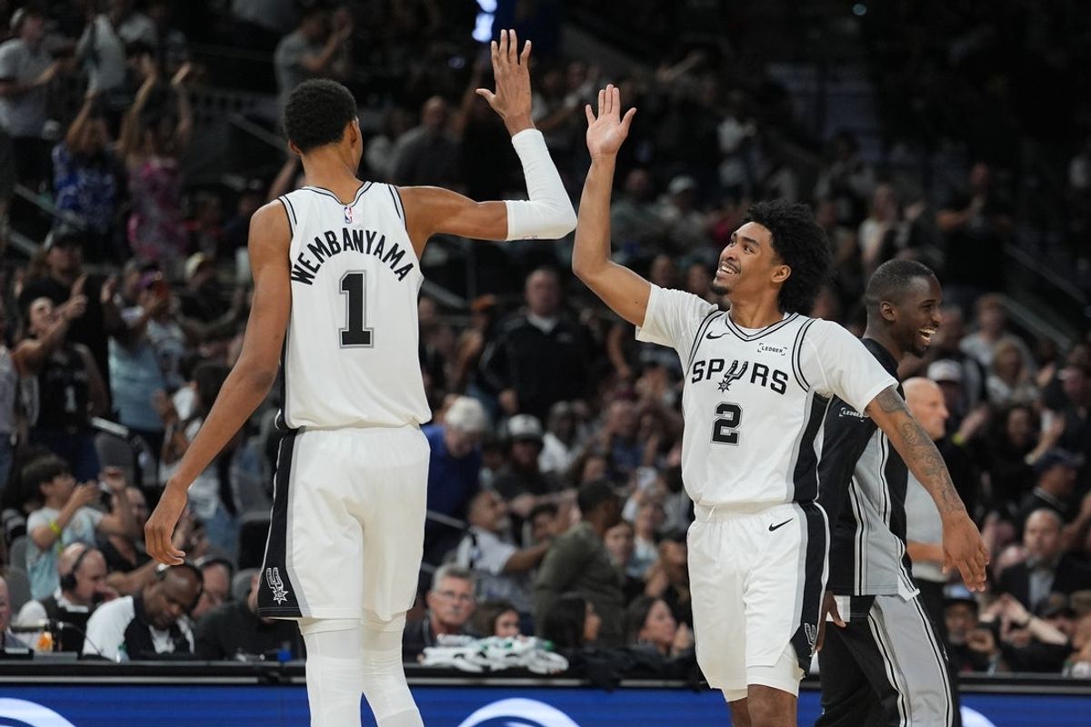 Oct 26, 2025; San Antonio, Texas, USA; San Antonio Spurs forward Victor Wembanyama (1) and guard Dylan Harper (2) celebrates in the second half against the Brooklyn Nets at Frost Bank Center. Mandatory Credit: Daniel Dunn-Imagn Images