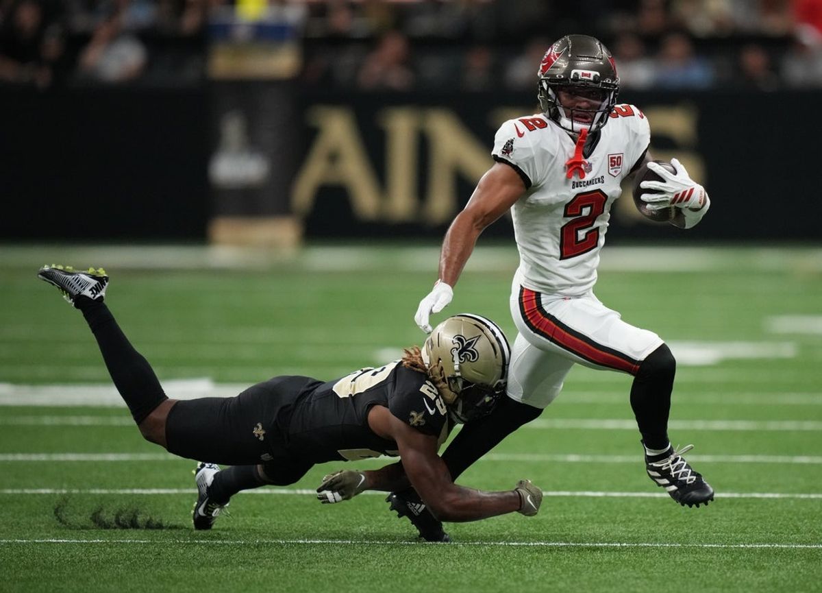 Oct 26, 2025; New Orleans, Louisiana, USA;  Tampa Bay Buccaneers wide receiver Emeka Egbuka (2) runs for a gain past New Orleans Saints cornerback Quincy Riley (29) during the third quarter at Caesars Superdome. Mandatory Credit: Matthew Hinton-Imagn Images