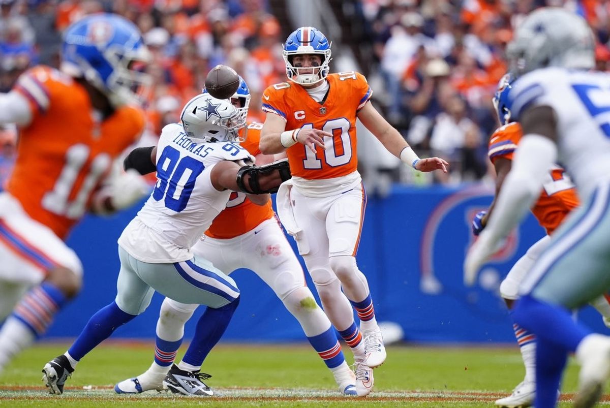 Oct 26, 2025; Denver, Colorado, USA; Denver Broncos quarterback Bo Nix (10) throws a pass against Dallas Cowboys defensive tackle Solomon Thomas (90) in the first half at Empower Field at Mile High. Mandatory Credit: Ron Chenoy-Imagn Images