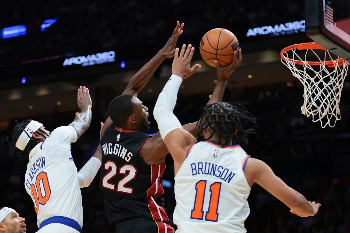 Oct 26, 2025; Miami, Florida, USA; Miami Heat forward Andrew Wiggins (22) drives to the basket against New York Knicks guard Jalen Brunson (11) and guard Jordan Clarkson (00) during the second quarter at Kaseya Center. Mandatory Credit: Sam Navarro-Imagn Images