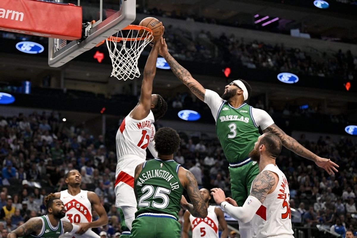 Oct 26, 2025; Dallas, Texas, USA; Toronto Raptors forward Collin Murray-Boyles (12) and Dallas Mavericks forward Anthony Davis (3) battle for the rebound during the second quarter at the American Airlines Center. Mandatory Credit: Jerome Miron-Imagn Images