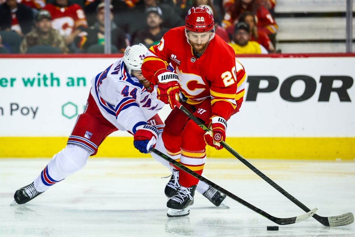 Oct 26, 2025; Calgary, Alberta, CAN; Calgary Flames left wing Blake Coleman (20) and New York Rangers defenseman Vladislav Gavrikov (44) battles for the puck during the second period at Scotiabank Saddledome. Mandatory Credit: Sergei Belski-Imagn Images
