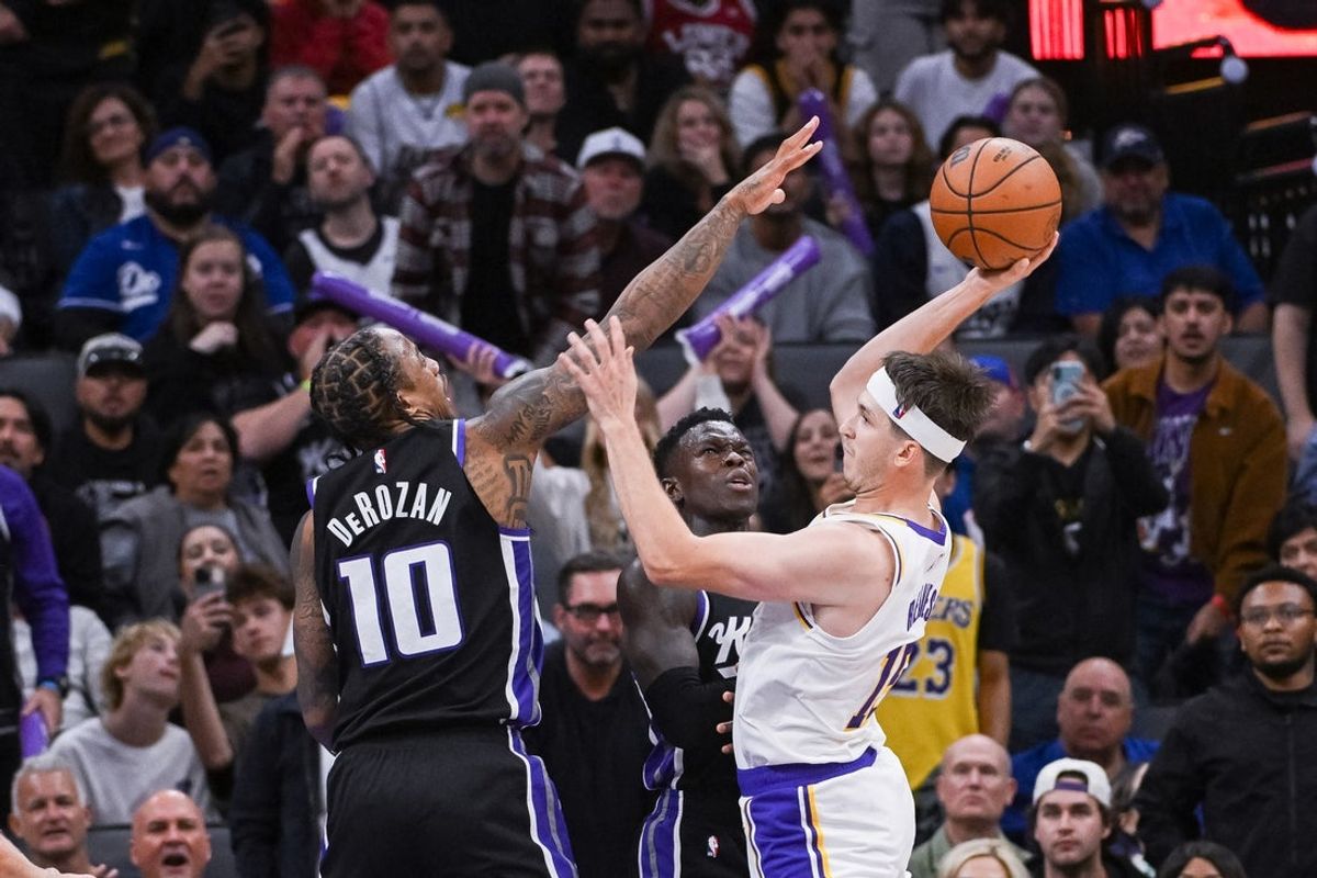 Oct 26, 2025; Sacramento, California, USA; Los Angeles Lakers guard Austin Reaves (15) looks to pass the ball against Sacramento Kings guard/forward Demar Derozan (10) during the fourth quarter at Golden 1 Center. Mandatory Credit: Ed Szczepanski-Imagn Images