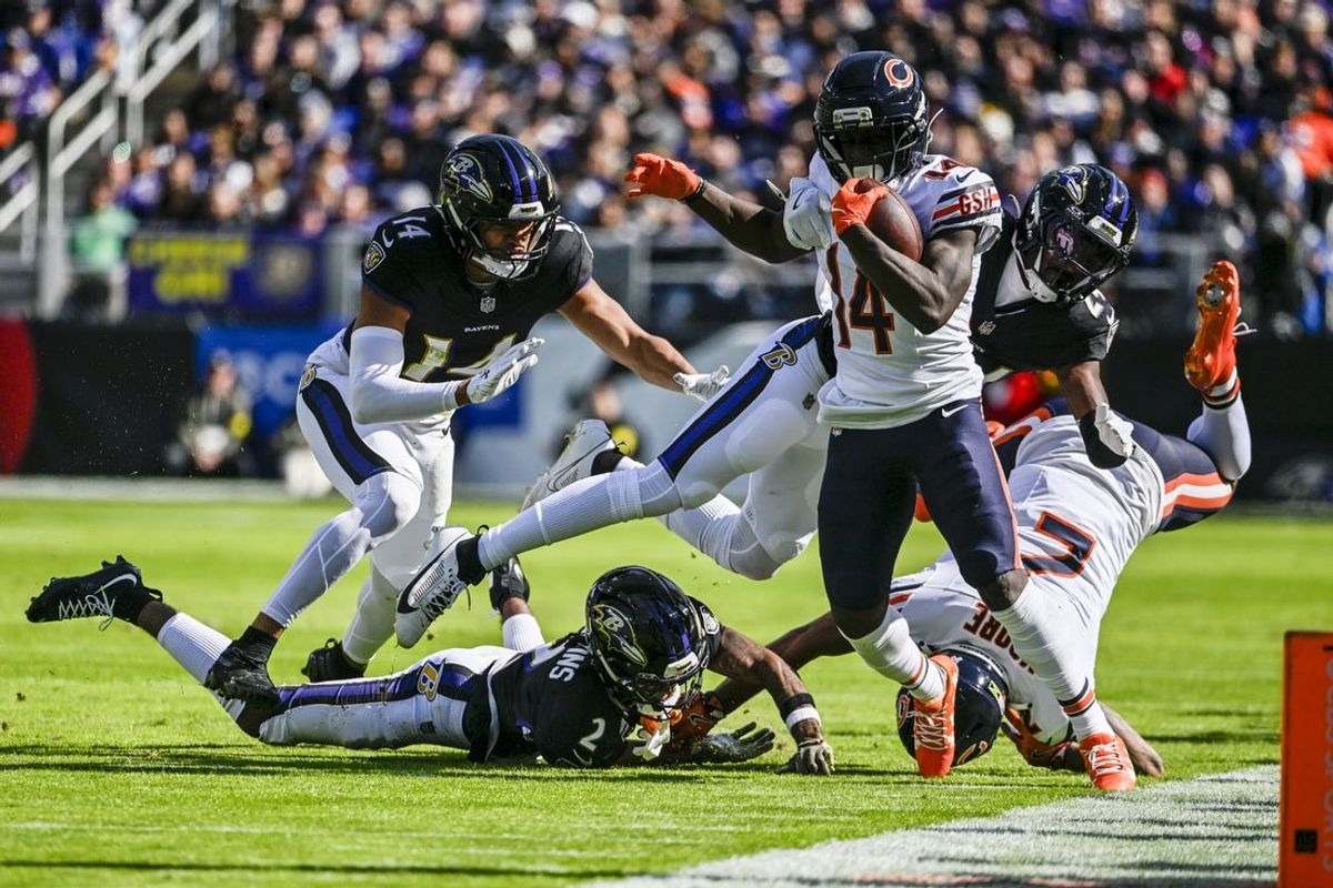 Oct 26, 2025; Baltimore, Maryland, USA;  Chicago Bears wide receiver Olamide Zaccheaus (14) runs after the catch as Baltimore Ravens cornerback Jaire Alexander (23) dives to tackle at M&T Bank Stadium. Mandatory Credit: Tommy Gilligan-Imagn Images