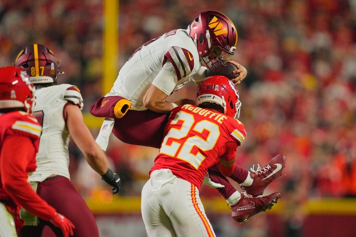 Oct 27, 2025; Kansas City, Missouri, USA; Kansas City Chiefs cornerback Trent McDuffie (22) tackles Washington Commanders quarterback Marcus Mariota (8) during the second quarter of the game at GEHA Field at Arrowhead Stadium. Mandatory Credit: Jay Biggerstaff-Imagn Images