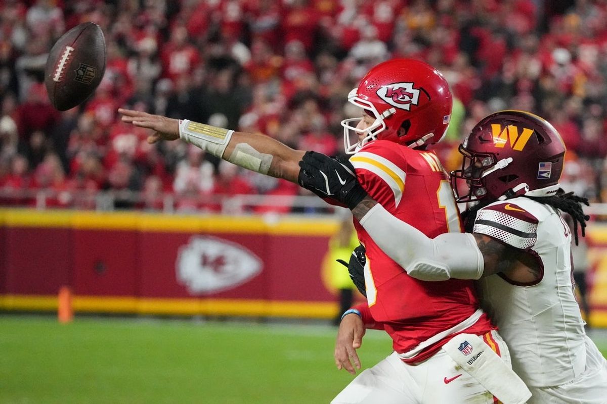 Oct 27, 2025; Kansas City, Missouri, USA; Kansas City Chiefs quarterback Patrick Mahomes (15) passes the ball defended by Washington Commanders linebacker Frankie Luvu (4) during the second quarter of the game at GEHA Field at Arrowhead Stadium. Mandatory Credit: Denny Medley-Imagn Images