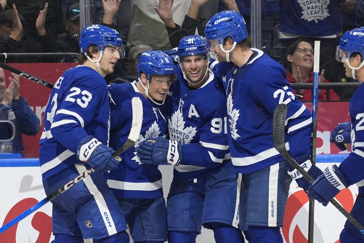 Oct 28, 2025; Toronto, Ontario, CAN; Toronto Maple Leafs forward Matthew Knies (23) and forward John Tavares (91) and defenseman Brandon Carlo (25) congratulate forward Max Domi (11) on scoring the game winning goal against the Calgary Flames during the third period at Scotiabank Arena. Mandatory Credit: John E. Sokolowski-Imagn Images