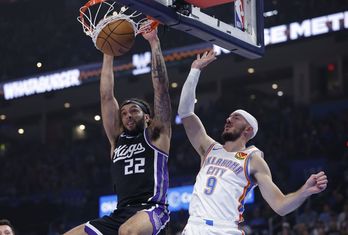 Oct 28, 2025; Oklahoma City, Oklahoma, USA;Sacramento Kings guard Devin Carter (22) dunks against Oklahoma City Thunder guard Alex Caruso (9) during the second quarter at Paycom Center. Mandatory Credit: Alonzo Adams-Imagn Images