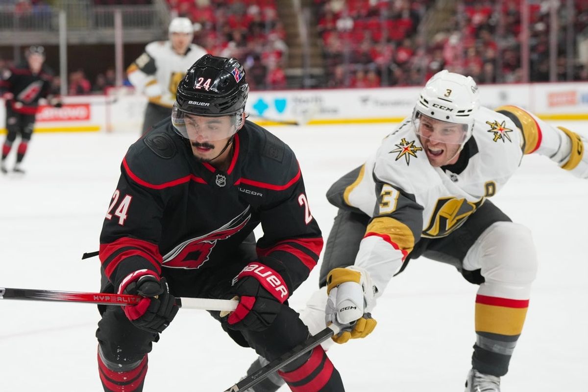 Oct 28, 2025; Raleigh, North Carolina, USA; Carolina Hurricanes center Seth Jarvis (24) and Vegas Golden Knights defenseman Brayden McNabb (3) chase after the puck during the third period at Lenovo Center. Mandatory Credit: James Guillory-Imagn Images
