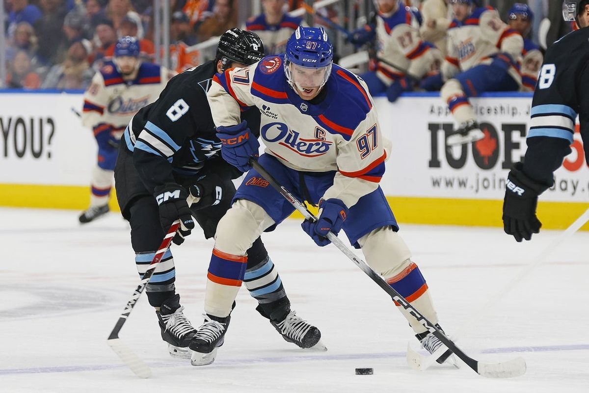 Oct 28, 2025; Edmonton, Alberta, CAN; Edmonton Oilers forward Connor McDavid (97) protects the puck from Utah Mammoth forward Nick Schmaltz (8) during the first period at Rogers Place. Mandatory Credit: Perry Nelson-Imagn Images
