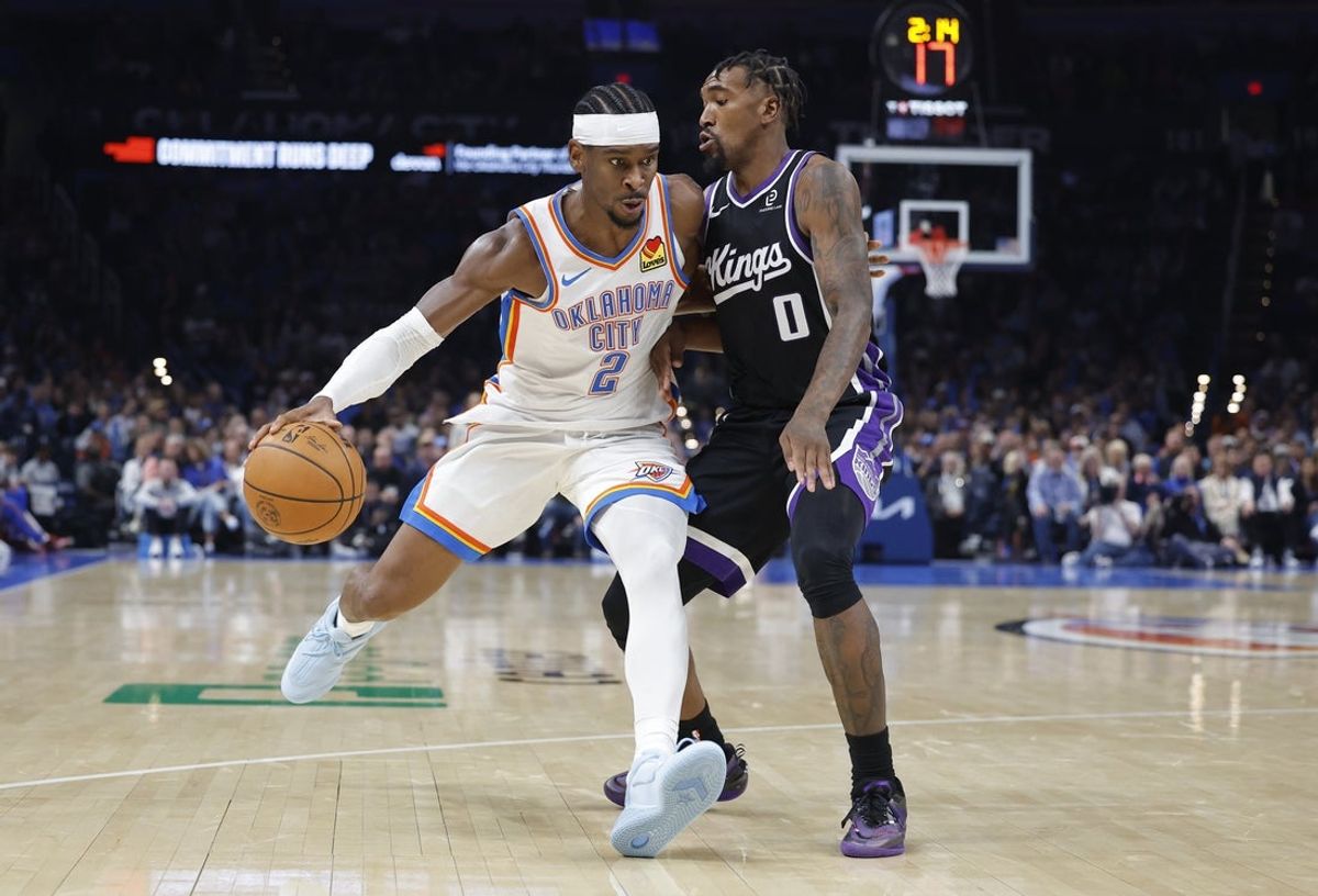 Oct 28, 2025; Oklahoma City, Oklahoma, USA; Oklahoma City Thunder guard Shai Gilgeous-Alexander (2) drives past Sacramento Kings guard Malik Monk (0) during the second half at Paycom Center. Mandatory Credit: Alonzo Adams-Imagn Images