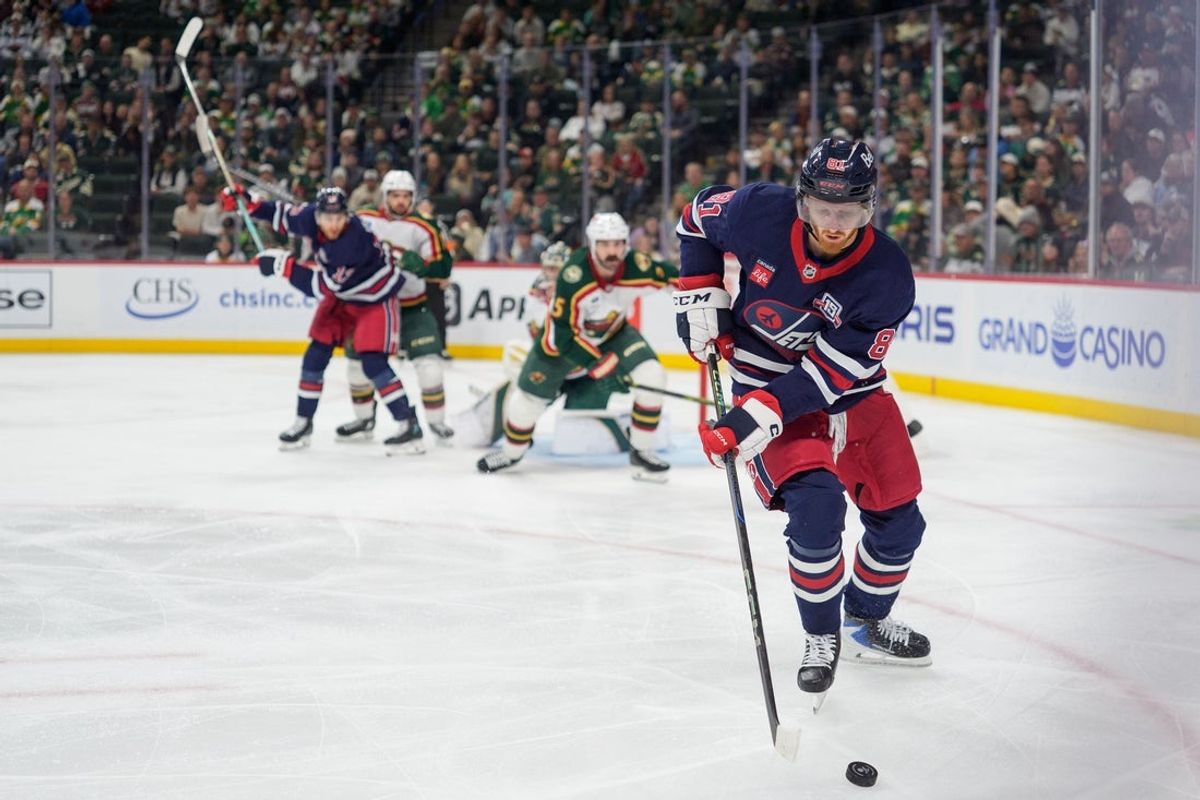 Oct 28, 2025; Saint Paul, Minnesota, USA; Winnipeg Jets left wing Kyle Connor (81) secures the puck in the Minnesota Wild zone in the third period at Grand Casino Arena. Mandatory Credit: Matt Blewett-Imagn Images