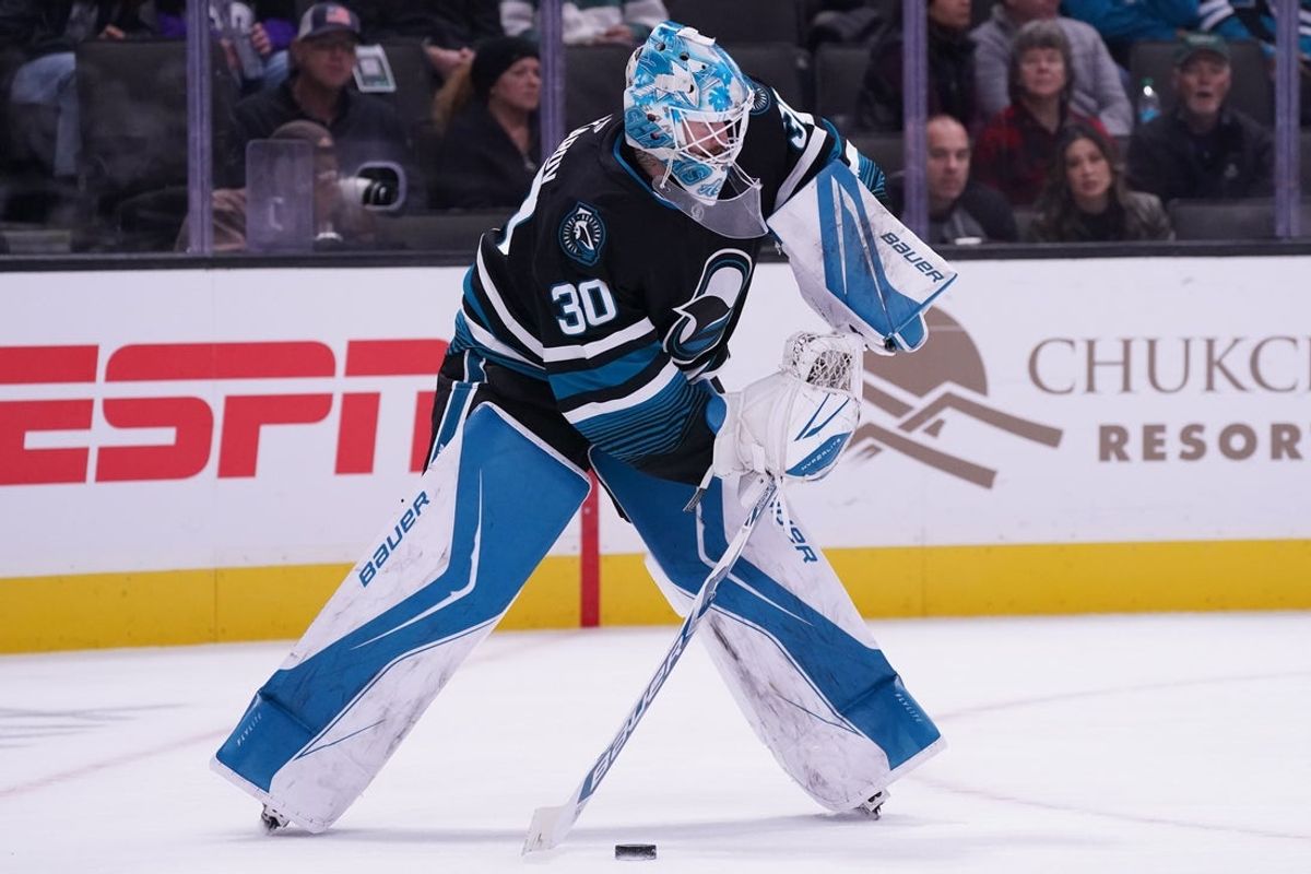 Oct 28, 2025; San Jose, California, USA; San Jose Sharks goaltender Yaroslav Askarov (30) looks to clear the puck against the Los Angeles Kings in the first period at SAP Center at San Jose. Mandatory Credit: David Gonzales-Imagn Images