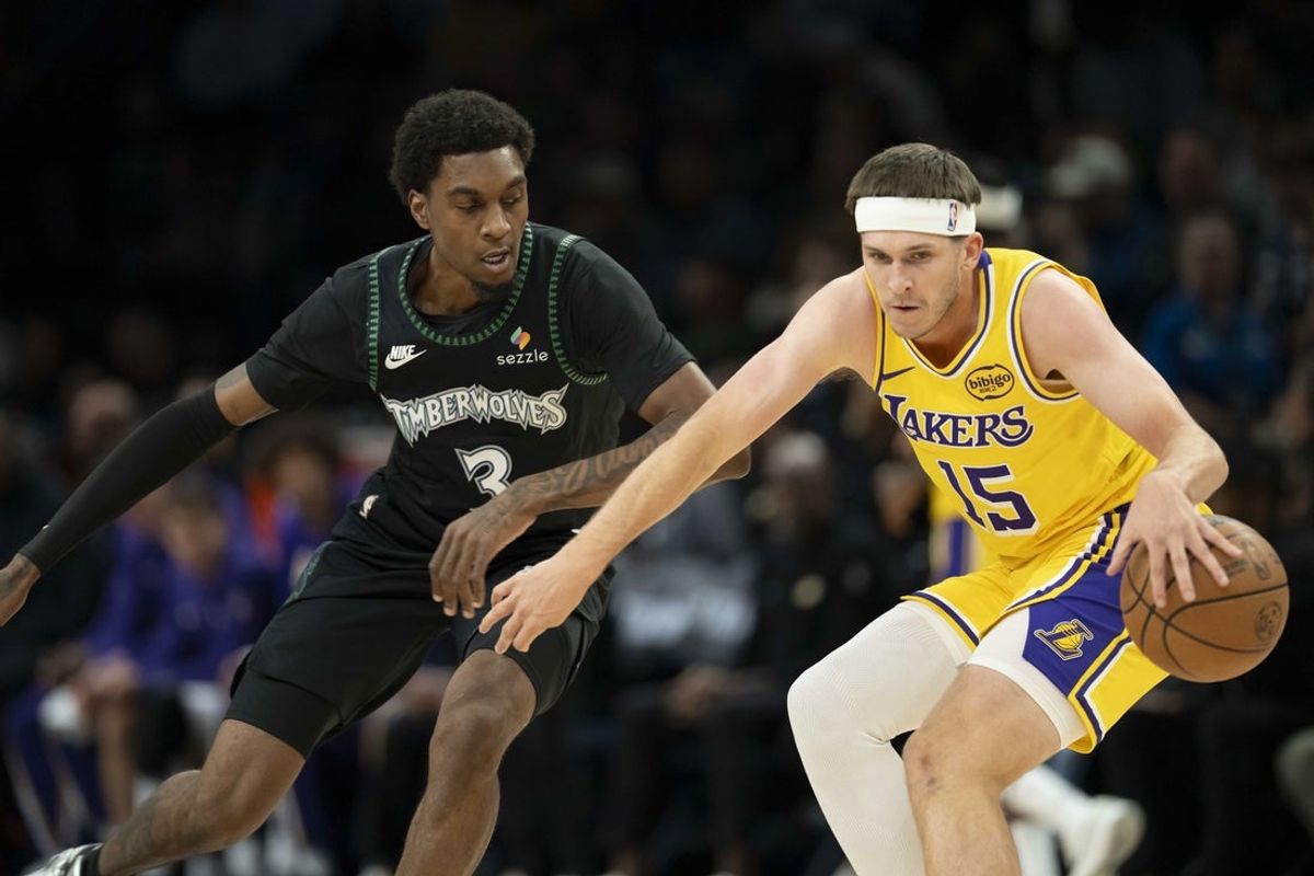 Oct 29, 2025; Minneapolis, Minnesota, USA; Los Angeles Lakers guard Austin Reaves (15) dribbles the ball as Minnesota Timberwolves forward Jaden McDaniels (3) plays defense in the first half at Target Center. Mandatory Credit: Jesse Johnson-Imagn Images