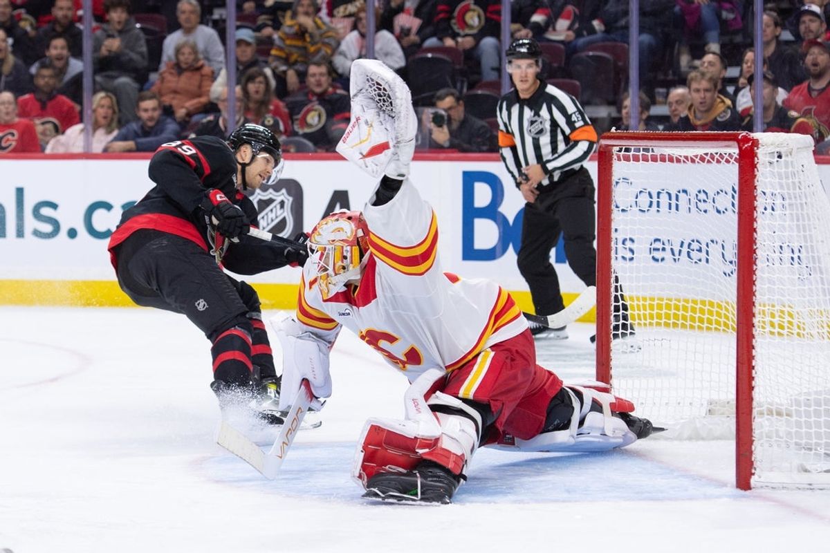 Oct 30, 2025; Ottawa, Ontario, CAN; Ottawa Senators center Lars Eller (89) scores against Calgary Flames goalie Devin Cooley (1)  in the first period at the Canadian Tire Centre. Mandatory Credit: Marc DesRosiers-IMAGN Images